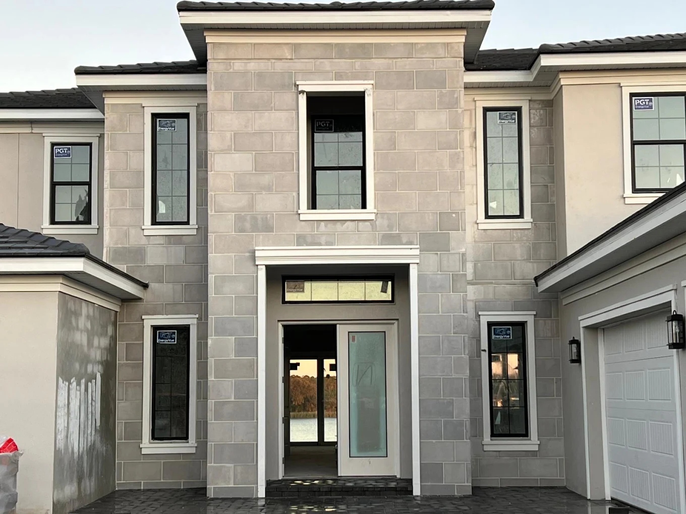 Two-story luxury home entrance with stone-block facade painted by Tony's Paint Solutions