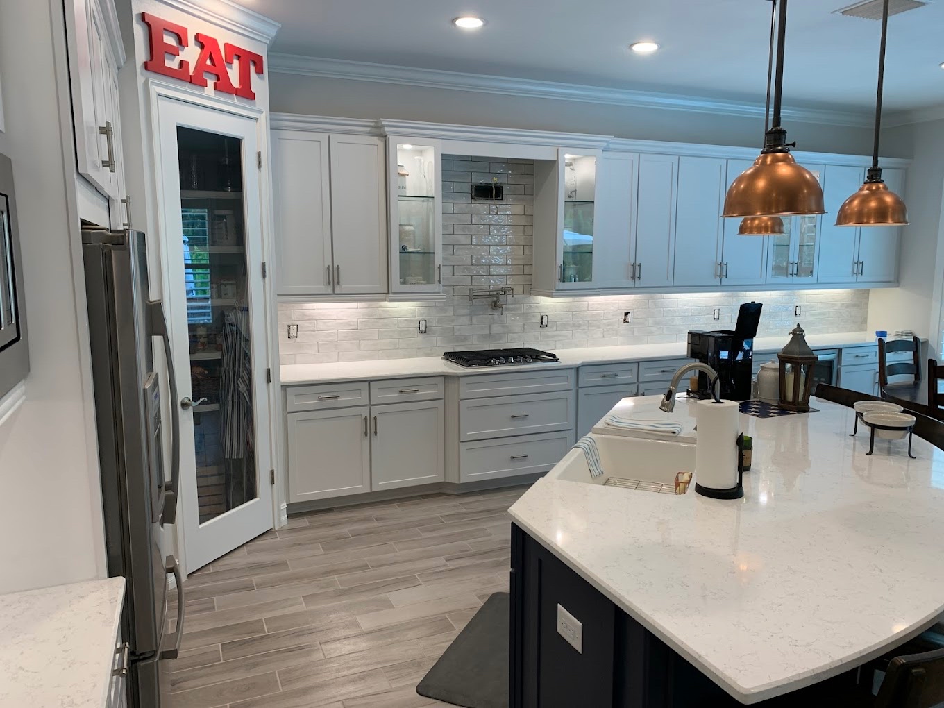 Bright white kitchen with painted cabinets and clean trim work by Tony's Paint Solutions
